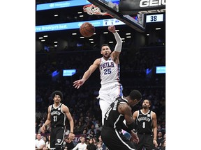 Philadelphia 76ers guard Ben Simmons (25) dunks over Brooklyn Nets forward Rondae Hollis-Jefferson (24) as Nets center Jarrett Allen (31) and guard Spencer Dinwiddie (8) look on during the first half of an NBA basketball game, Sunday, Nov. 4, 2018, in New York.
