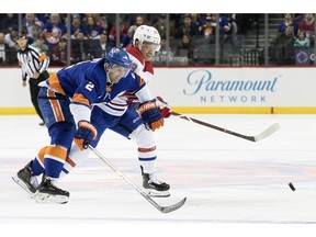 New York Islanders defenseman Nick Leddy, left,  and Montreal Canadiens left wing Max Domi, right, chase a loose puck in the first period of an NHL hockey game, Monday, Nov. 5, 2018, in New York.
