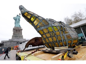 The original torch of the Statue of Liberty rests on a hydraulically stabilized transporter, Thursday, Nov. 15, 2018 in New York. The torch, which was removed in 1984 and replaced by a replica, was being moved into what will become its permanent home at a new museum on Liberty Island.