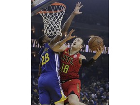 Atlanta Hawks center Miles Plumlee (18) shoots against Golden State Warriors forward Alfonzo McKinnie (28) during the first half of an NBA basketball game in Oakland, Calif., Tuesday, Nov. 13, 2018.