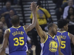 Golden State Warriors forward Kevin Durant (35) celebrates with forward Andre Iguodala (9) during the second half of an NBA basketball game against the Brooklyn Nets in Oakland, Calif., Saturday, Nov. 10, 2018.