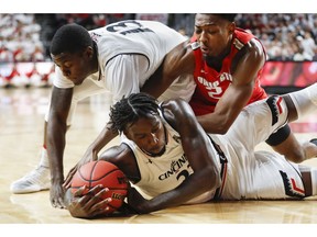 Cincinnati's Nysier Brooks, center, battles for the ball with Ohio State's Andre Wesson, right, during the first half of an NCAA basketball game, Wednesday, Nov. 7, 2018, in Cincinnati.