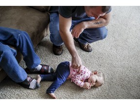 Tom Wolikow, a General Motors employee who is currently laid-off, plays with his daughter Annabella at their home, Wednesday, Nov. 28, 2018, in Warren, Ohio. Even though unemployment is low, the economy is growing and U.S. auto sales are near historic highs, GM is cutting thousands of jobs in a major restructuring aimed at generating cash to spend on innovation. GM put five plants up for possible closure, including the plant in Lordstown.