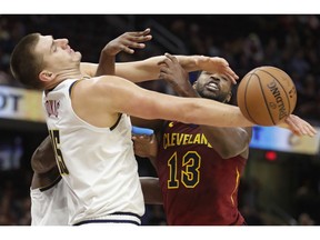 Denver Nuggets' Nikola Jokic, left, vies for the ball with Cleveland Cavaliers' Tristan Thompson during the first half of an NBA basketball game Thursday, Nov. 1, 2018, in Cleveland.