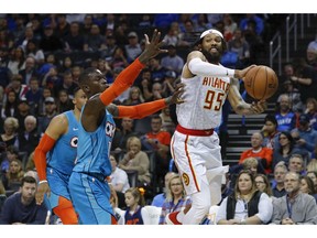 Atlanta Hawks forward DeAndre' Bembry (95) passes the ball around Oklahoma City Thunder guard Dennis Schroeder (17) during the first half of an NBA basketball game in Oklahoma City, Friday, Nov. 30, 2018.