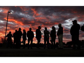 Voters line up to cast their ballots shortly before the polls open in the midterm elections at First Church in Owasso, Okla., Tuesday, Nov. 6, 2018.