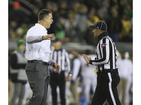 Oregon head football coach Mario Cristobal, left, talks to a referee during the second quarter against Arizona State in an NCAA college football game Saturday, Nov. 17, 2018, in Eugene, Ore.