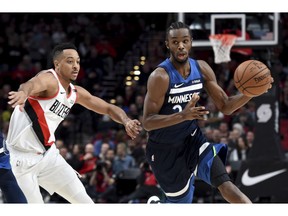 Minnesota Timberwolves forward Andrew Wiggins, right, tries to get past Portland Trail Blazers guard CJ McCollum, left, during the first quarter of an NBA basketball game in Portland, Ore., Sunday, Nov. 4, 2018.