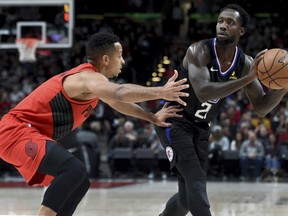 Los  Angeles Clippers guard Patrick Beverley, right, looks to pass the ball on Portland Trail Blazers guard CJ McCollum, left, during the first half of an NBA basketball game in Portland, Ore., Thursday, Nov. 8, 2018.
