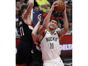 Milwaukee Bucks center Brook Lopez, right, shoots as Portland Trail Blazers forward Meyers Leonard, left, defends during the first half of an NBA basketball game in Portland, Ore., Tuesday, Nov. 6, 2018.