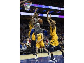 Philadelphia 76ers' Jimmy Butler, center, goes up to shoot against Utah Jazz's Derrick Favors, left, and Rudy Gobert, right, of France, during the first half of an NBA basketball game, Friday, Nov. 16, 2018, in Philadelphia.