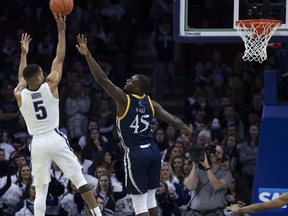 Villanova's Phil Booth, left, shoots over Quinnipiac's Kevin Marfo during the second half of an NCAA college basketball game Saturday, Nov. 10, 2018, in Philadelphia.