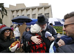 Rabbi Chuck Diamond, center, a former Rabbi at the Tree of Life Synagogue, hugs a woman after leading a Shabbat service outside the Tree of Life Synagogue, Saturday, Nov. 3, 2018 in Pittsburgh. Last Saturday, 11 people were killed and six wounded when their worship was interrupted by a gunman's bullets.