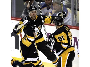 Pittsburgh Penguins' Phil Kessel (81) celebrates his goal with Tanner Pearson (14) and Evgeni Malkin (71) in the first period of an NHL hockey game against the Buffalo Sabres in Pittsburgh, Monday, Nov. 19, 2018.