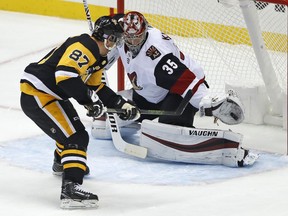 Arizona Coyotes goaltender Darcy Kuemper (35) gloves a backhand shot by Pittsburgh Penguins' Sidney Crosby (87) during the first period of an NHL hockey game in Pittsburgh, Saturday, Nov. 10, 2018.