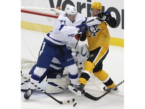 Pittsburgh Penguins' Patric Hornqvist (72) works against Tampa Bay Lightning's Anthony Cirelli (71) in front of Lightning goalie Louis Domingue during the first period of an NHL hockey game in Pittsburgh, Thursday, Nov. 15, 2018.