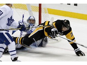 Pittsburgh Penguins' Derek Grant (38) trips over Toronto Maple Leafs goaltender Frederik Andersen during the first period of an NHL hockey game in Pittsburgh, Saturday, Nov. 3, 2018.
