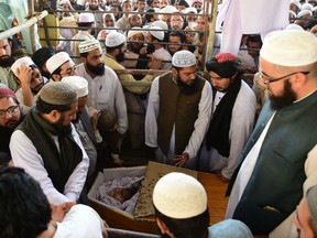 Pakistani supporters take a last glimpse of the body of key cleric Maulana Sami Ul-Haq during his funeral ceremony in his hometown of Akora Khattak, located around 115 kilometres northwest of Islamabad, on November 3, 2018.