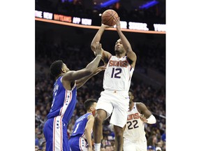 Phoenix Suns' TJ Warren (12) shoots the ball over Philadelphia 76ers' Amir Johnson in the first half of an NBA basketball game, Monday, Nov. 19, 2018, in Philadelphia.