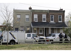 Police gather at the scene of a fatal shooting in the center row home in Philadelphia, Monday, Nov. 19, 2018. Police say two men and two women have been found shot and killed in a basement in Philadelphia.