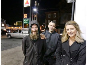 FILE – In this Nov. 17, 2017, file photo, Johnny Bobbitt Jr., left, Kate McClure, right, and McClure's boyfriend Mark D'Amico pose at a Citgo station in Philadelphia.  A New Jersey prosecutor was set to announce developments Thursday, Nov. 15, 2018, in a criminal investigation of  the couple that raised $400,000 for Bobbitt Jr, a homeless man they said helped them with a disabled car. Burlington County Prosecutor Scott Coffina planned to discuss the matter during a news conference. He declined to provide further details about the announcement or whether criminal charges would be brought in the case.