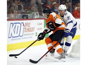 Philadelphia Flyers' Travis Konecny, left, is challenged behind the net by Tampa Bay Lightning' Brayden Point during the second period of an NHL hockey game Saturday, Nov. 17, 2018, in Philadelphia.