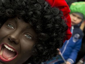 In this Saturday, Nov. 12, 2016 file photo, a Black Pete interacts with children during the arrival of Sinterklaas in Maassluis, Netherlands, Saturday, Nov. 12, 2016. Saturday, Nov. 12, 2016. A court in the Netherlands has convicted 34 people on Friday NOv. 9, 2018, who blocked a highway last year to prevent anti-racism demonstrators reaching the nationally televised arrival of Sinterklaas, the Dutch version of Santa Claus, and his helpers called "Zwarte Piet", or Black Petes. Black Pete is often played by white people with their faces daubed in dark makeup.