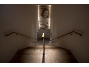 A picture of Anne Frank accompanies visitors as they leave the renovated Anne Frank House Museum in Amsterdam, Netherlands, Wednesday, Nov. 21, 2018. The museum is built around the secret annex hidden in an Amsterdam canal-side house where teenage Jewish diarist Anne Frank hid from Nazi occupiers during World War II is expanding to better tell Anne's tragic story to the growing number of visitors.