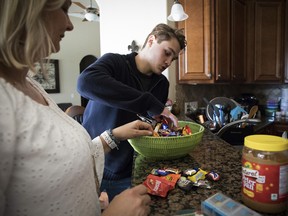 Carolee Grodi and her son, Carter Grodi, 16, sort Halloween candy at their home in Ocala, Fla., Nov. 16, 2018.