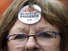 Shirley Taylor wears a "Burnt by Phoenix" sticker on her forehead during a rally against the Phoenix payroll system outside the offices of the Treasury Board of Canada in Ottawa on Wednesday, Feb. 28, 2018.