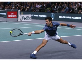 Novak Djokovic of Serbia stretches for the ball return it to Karen Khachanov of Russia during their final match of the Paris Masters tennis tournament at the Bercy Arena in Paris, France, Sunday, Nov. 4, 2018.