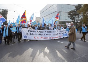 Uyghurs and Tibetan people demonstrate against China during the Universal Periodic Review of China by the Human Rights Council, walking to the place des Nations in front of the European headquarters of the United Nations, in Geneva, Switzerland, Tuesday, Nov. 6, 2018.