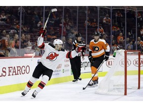 New Jersey Devils' Blake Coleman, left, reacts past Philadelphia Flyers' Christian Folin after a goal by Joey Anderson during the first period of an NHL hockey game, Thursday, Nov. 15, 2018, in Philadelphia.