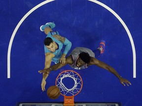 Charlotte Hornets' Willy Hernangomez, left, goes up for a shot against Philadelphia 76ers' Joel Embiid during the second half of an NBA basketball game, Friday, Nov. 9, 2018, in Philadelphia. Philadelphia won 133-132 in overtime.