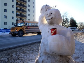 A snow figure waves to passing vehicles on John Counter Boulevard, just west of Montreal Street in Kingston, Ont.