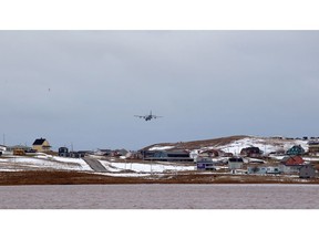 A Canadian Forces CC-130 Hercules transport aircraft descends into an airport on Quebec's Isles-de-la-Madeleine Islands, on Friday, Nov. 30, 2018. Life on the Iles-de-la-Madeleine is slowly returning to normal today after a fierce winter storm cut residents off from the rest of the province and sent waves crashing into coastal homes and across roads.THE CANADIAN PRESS/Nigel Quinn