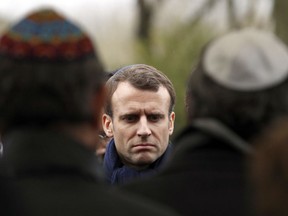 FILE - In this Wednesday, March 28, 2018 file picture French President Emmanuel Macron attends Mireille Knoll's funerals at the Bagneux cemetery , outside Paris. Family members and friends gathered Wednesday to honor an 85-year-old woman who escaped the Nazis 76 years ago but was stabbed to death last week in her Paris apartment, apparently because she was Jewish. France's prime minister is sounding the alarm over a sharp rise in anti-Semitic acts this year, pledging to increase efforts to punish perpetrators and police hate speech online.