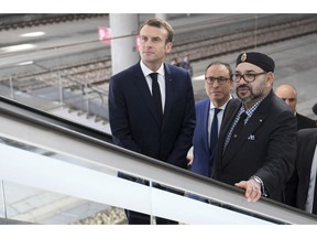 Moroccan King Mohammed VI and French President Emmanuel Macron, left, stand on an escalator after inaugurating a high-speed line at Rabat train station, Morocco, Thursday, Nov. 15, 2018. Macron is in Morocco to take part in the inauguration of a high-speed railway line that boasts the fastest journey times in Africa or the Arab world.