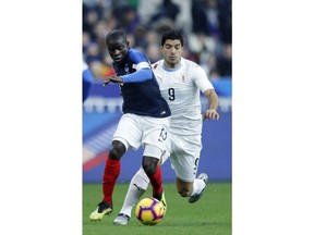France's Ngolo Kante, left, challenges for the ball with Uruguay's Luis Suarez during an international friendly soccer match between France and Uruguay at the Stade de France stadium in Saint-Denis, outside Paris, Tuesday, Nov. 20, 2018.