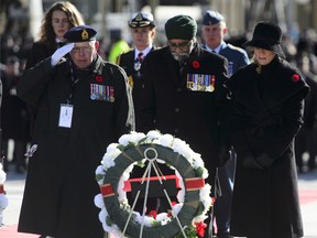 Minister of National Defence Minister Harjit Sajjan, centre, and Sophie Gregoire-Trudeau place a wreath during Remembrance Day ceremonies at the National War Memorial in Ottawa on Sunday, Nov. 11, 2018.