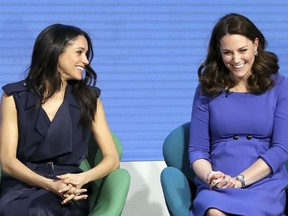Meghan Markle, left, and Kate, Duchess of Cambridge laugh during the first annual Royal Foundation Forum in London, Wednesday Feb. 28, 2018.