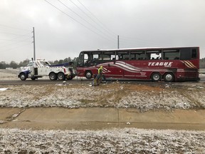 A tour bus is towed away Wednesday, Nov. 14, 2018, after it overturned on an icy highway in northern Mississippi. DeSoto County sheriff's deputy Alex Coker said the tour bus carrying about 50 people overturned just after midday Wednesday south of Memphis, Tennessee. The crash came as a winter storm has been raking parts of the South. The county coroner, Josh Pounders, says two people are confirmed dead in the crash where Interstate 269 meets with Interstate 22. He says that the injured have been taken to area hospitals, some in critical condition.