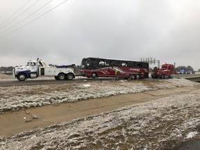A tour bus is towed away Wednesday, Nov. 14, 2018, after it overturned on an icy highway in northern Mississippi. DeSoto County sheriff's deputy Alex Coker said the tour bus carrying about 50 people overturned just after midday Wednesday south of Memphis, Tennessee. The crash came as a winter storm has been raking parts of the South. The county coroner, Josh Pounders, says two people are confirmed dead in the crash where Interstate 269 meets with Interstate 22. He says that the injured have been taken to area hospitals, some in critical condition.
