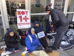 Supporters of Nelson Pinos, facing deportation, block the front doors of the federal building, Friday, Nov. 30, 2018, in Hartford, Conn. They are demanding that Immigration and Customs Enforcement allow Pinos, of Ecuador, to go home to his family in time for the holidays. He was ordered to leave the U.S. a few weeks before Christmas 2017. He instead sought sanctuary in a New Haven church.