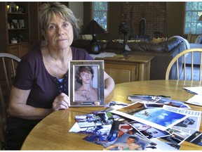 In this Oct. 9, 2018 photo, Linda Marino poses with photographs of her son, Samuel, at her home in Tolland, Conn. Samuel Marino died in a 2009 car crash that relatives believe was intentional after becoming a victim of a male sex trafficking ring. Advocates are calling for more recognition and services for male victims.