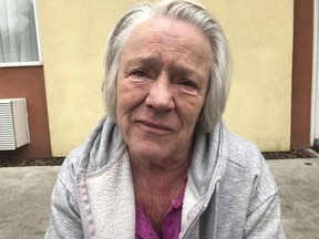 Linda Rawlings, a wildfire evacuee, sits outside a hotel in Corning, Calif., after finding out that her home in Magalia is gone.