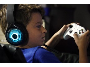 In this Saturday, Oct. 6, 2018, photo, Henry Hailey, 10, plays the online game Fortnite in the early morning hours in the basement of his Chicago home. His parents are on a quest to limit screen time for him and his brother. The boys say they understand sometimes, but also complain that they get less screen time than their friends.