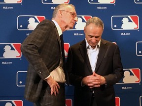 DAZN chairman John Skipper, left, speaks to Major League Baseball commissioner Rob Manfred at the baseball owners meeting in Atlanta, Thursday, Nov. 15, 2018.