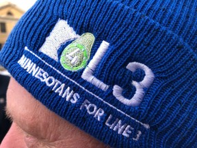 Blue-hatted supporters of Enbridge Energy's proposed Line 3 crude oil pipeline line up for a Minnesota Public Utilities Commission hearing on the project on Monday, November 19, 2018, in St. Paul, Minnesota.