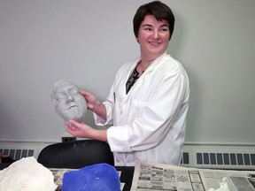 In this Monday, Oct. 22, 2018, photo, funeral services student Maeve Curran holds a mask at State University of New York at Canton. By measuring facial dimensions and symmetry, students learn how to restore facial features lost to illness or trauma on the deceased. Eighty percent of the undergraduate funeral director students at this school are female, mirroring a nationwide trend.